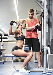 Image showing man and woman flexing muscles on gym machine