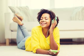 Image showing happy african woman with smartphone and headphones