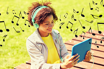 Image showing happy african woman in headphones with tablet pc