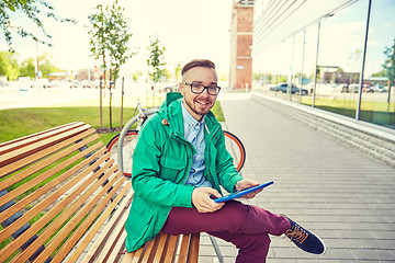 Image showing happy young hipster man with tablet pc and bike