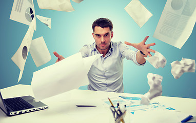 Image showing angry businessman throwing papers in office