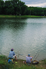 Image showing Couple catches fish with a fishing rod