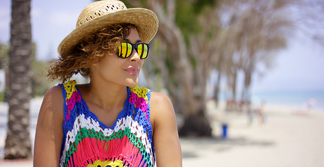 Image showing Grinning woman in sunglasses and hat near ocean