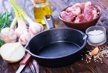 Image showing raw meat and pan on a table
