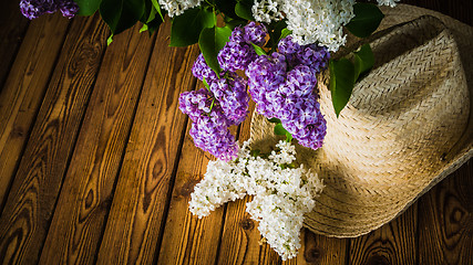 Image showing Bouquet of lilacs and a straw hat