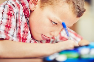 Image showing Boy is doing homework