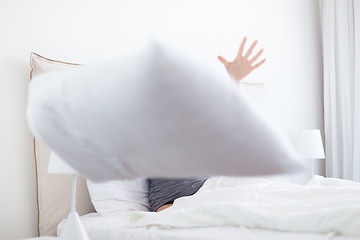 Image showing Woman throwing white pillow at camera.