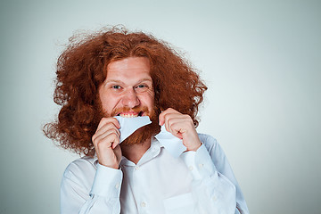 Image showing Angry man tear out paper