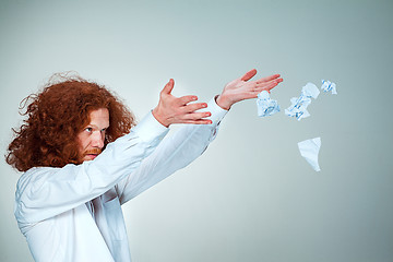 Image showing Angry man tear out paper