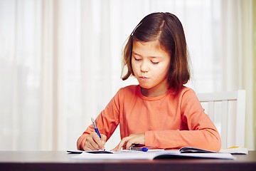 Image showing Girl is doing homework 