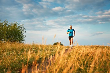 Image showing Athletic runner on the hillside