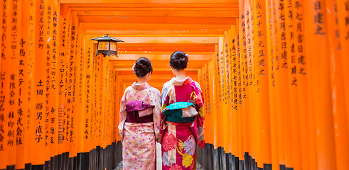 Image showing Two geishas among red wooden Tori Gate at Fushimi Inari Shrine in Kyoto, Japan