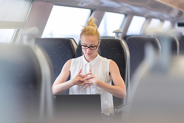 Image showing Woman streching while travelling by train.