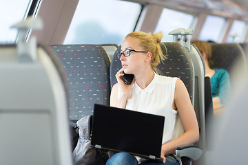 Image showing Business woman working while travelling by train.