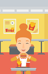 Image showing Woman eating hamburger. 