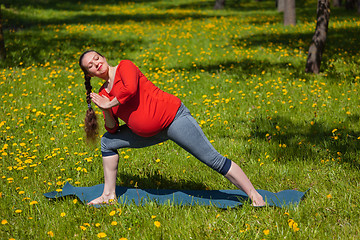 Image showing Pregnant woman doing asana Utthita parsvakonasana outdoors