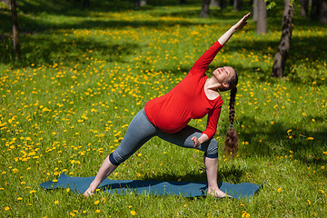 Image showing Pregnant woman doing asana Utthita parsvakonasana outdoors