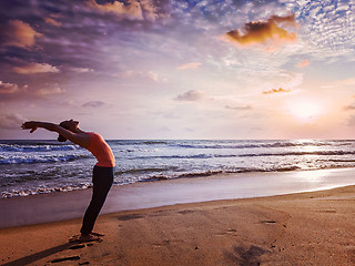 Image showing Young sporty fit woman doing yoga Sun salutation Surya Namaskar