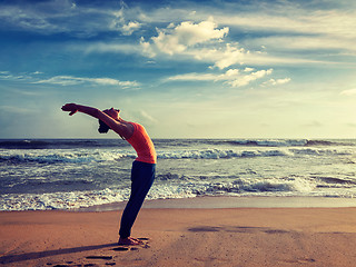 Image showing Young sporty fit woman doing yoga Sun salutation Surya Namaskar