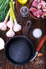 Image showing raw meat and pan on a table