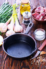 Image showing raw meat and pan on a table