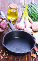 Image showing raw meat and pan on a table