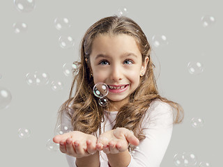 Image showing Girl playing with soap bubbles