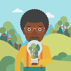 Image showing Man with lightbulb and trees inside.