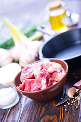 Image showing raw meat and pan on a table