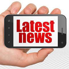 Image showing News concept: Hand Holding Smartphone with Latest News on display