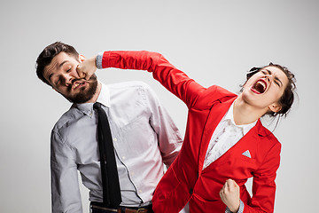 Image showing The angry business man and woman conflicting on a gray background