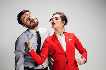 Image showing The angry business man and woman conflicting on a gray background