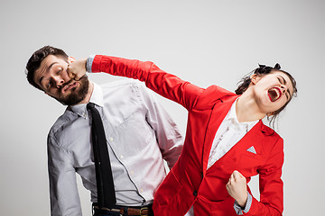 Image showing The angry business man and woman conflicting on a gray background