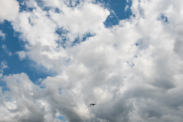 Image showing Airplane flying high in dramatic clouds