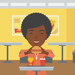 Image showing Woman eating hamburger. 