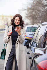 Image showing smiling middle aged brunette with smartphone