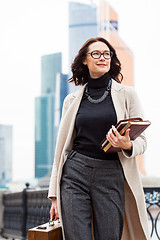 Image showing brunette with a wooden case and books in their hands