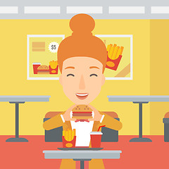 Image showing Woman eating hamburger. 