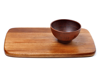 Image showing Empty ceramic bowl on wooden kitchen board