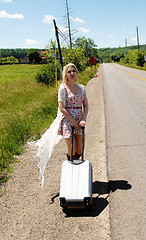 Image showing Young woman walking along street.