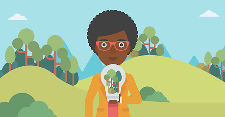 Image showing Woman with lightbulb and trees inside.