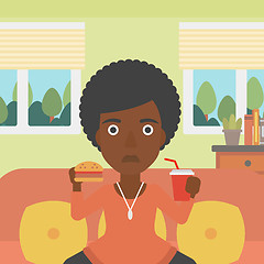 Image showing Woman eating hamburger. 