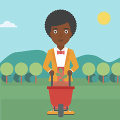 Image showing Woman with plant and wheelbarrow.