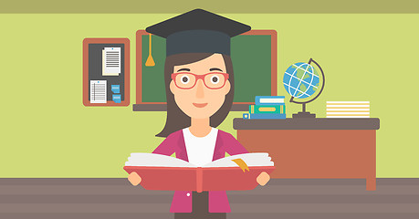 Image showing Woman in graduation cap holding book.