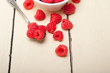 Image showing bunch of fresh raspberry on a bowl and white table