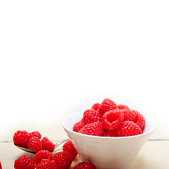 Image showing bunch of fresh raspberry on a bowl and white table