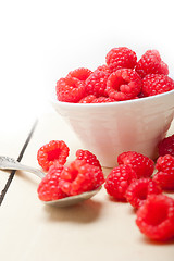 Image showing bunch of fresh raspberry on a bowl and white table