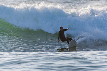 Image showing Long boarder surfing the waves at sunset