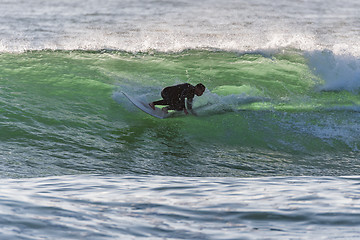 Image showing Long boarder surfing the waves at sunset