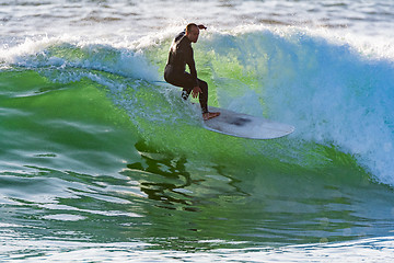 Image showing Long boarder surfing the waves at sunset